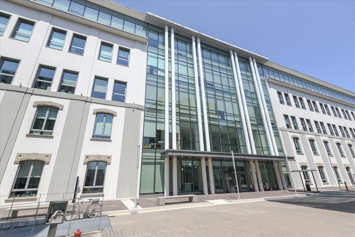 Exterior view of the modern glass and stone facade of the Mac4, Via Benigno Crespi 19 building.
