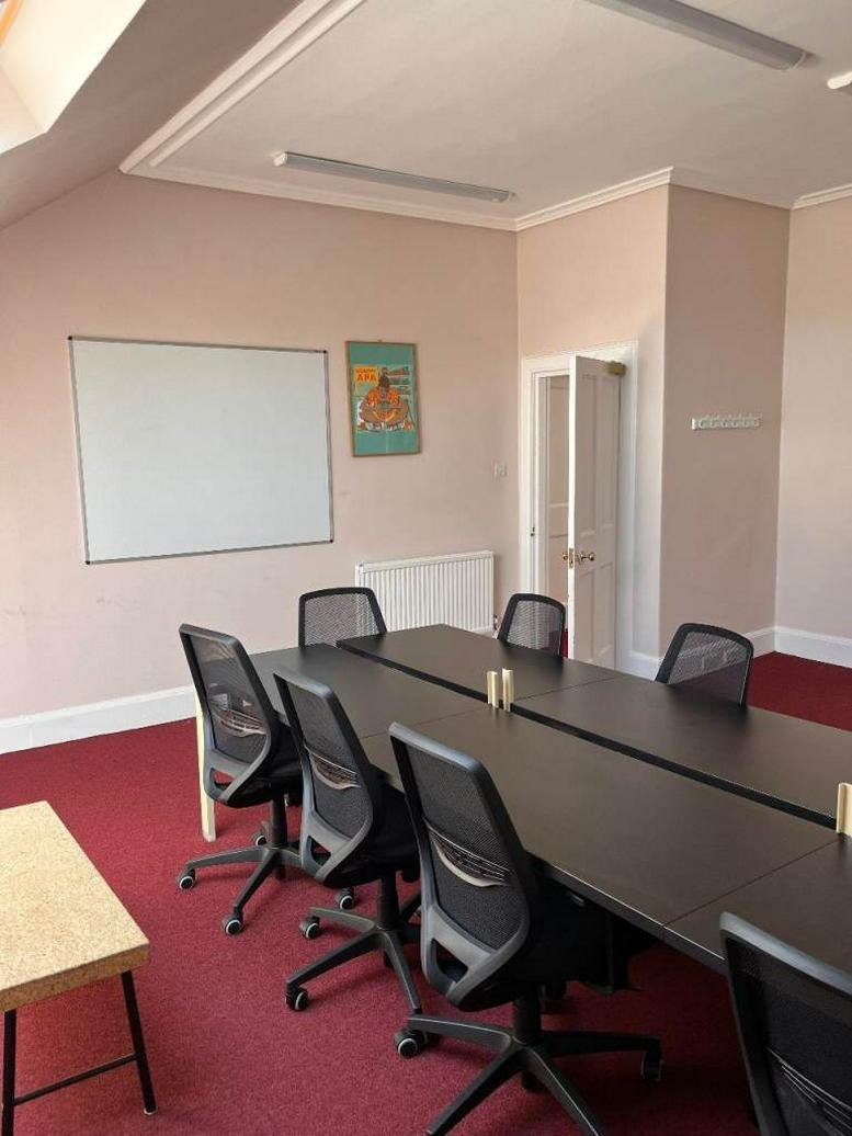 Spacious professional meeting room at Melville Street with black chairs and a whiteboard.