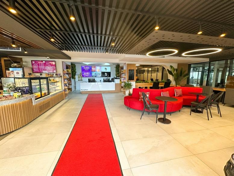 Spacious reception area at Namık Kemal Caddesi, No: 57/A with a red carpet and curved red sofa.