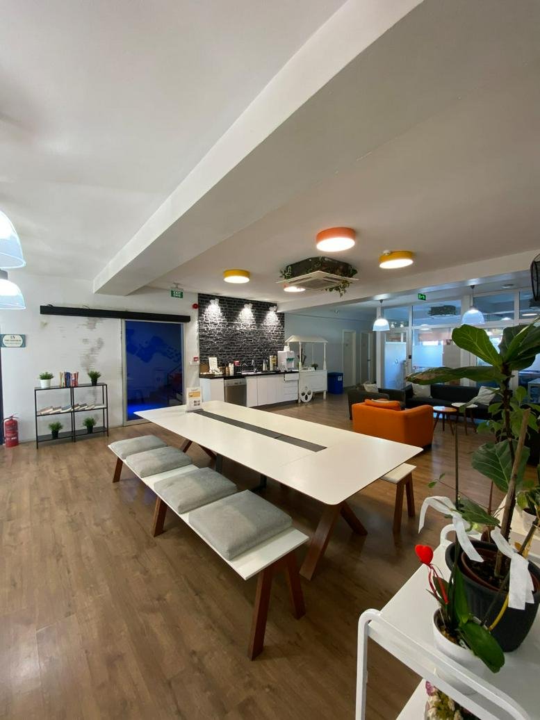 Spacious communal dining area at NO:3 /5, Dalgıç Sokak featuring a long white table and colorful seating.
