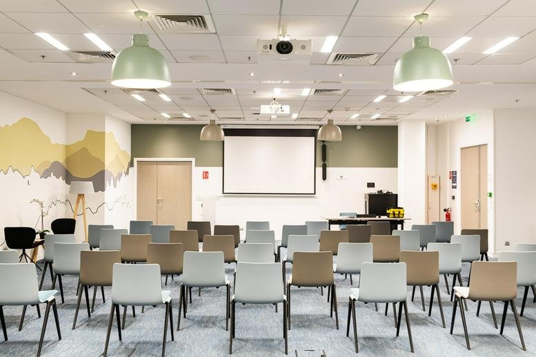 Spacious presentation room at 1 Avenue Du Président Wilson, Tour HYFIVE, featuring neat rows of chairs and a screen.