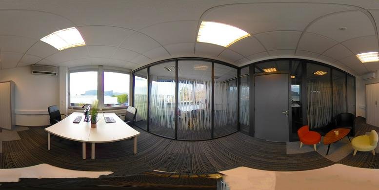 Panoramic view of a spacious office area with glass walls.