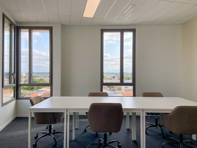 Meeting room at 11, Rue Ferdinand Buisson, Bègles with a white table and large windows.