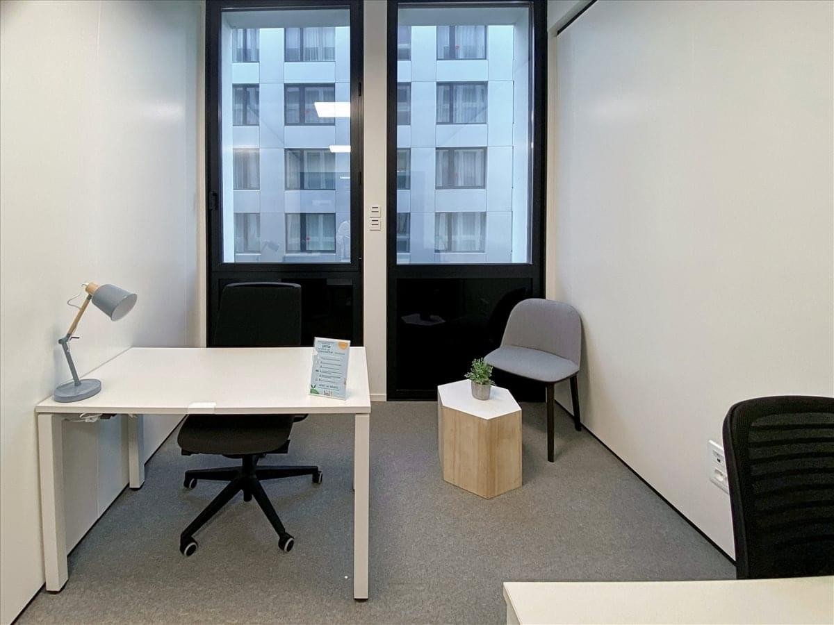 Private office suite at Immeuble Nouvel’R, Bâtiment B featuring a white desk and large windows.