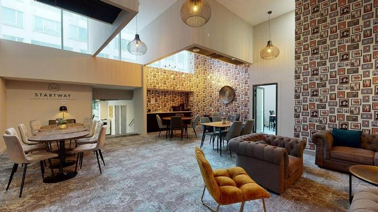 Spacious communal lounge at 143 rue d’Athènes with plush seating and decorative wallpaper.