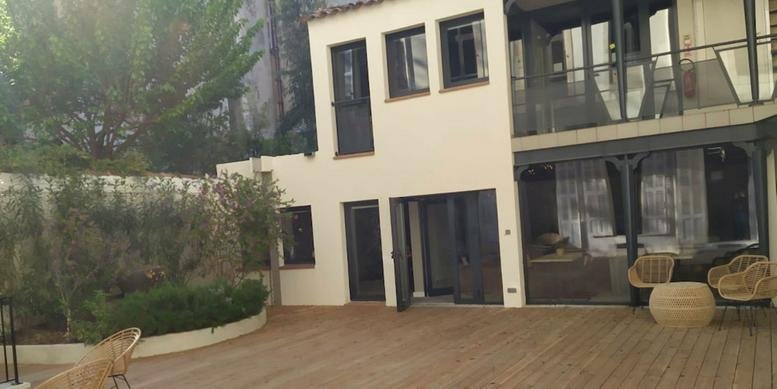 Exterior view of the white facade and courtyard at 18 rue Dieudé.