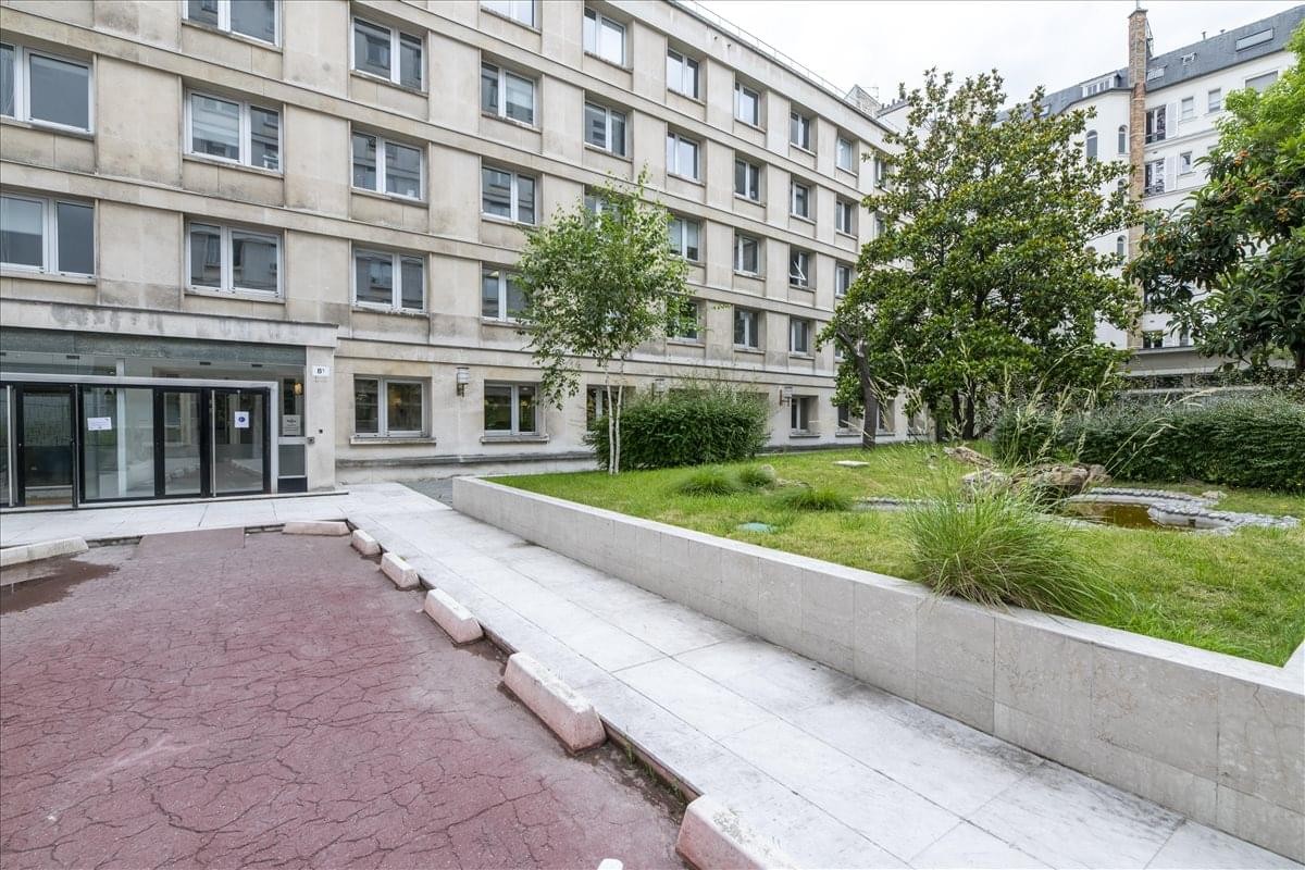 Exterior facade and entrance of the classic stone building at 191-195 Avenue Charles De Gaulle.