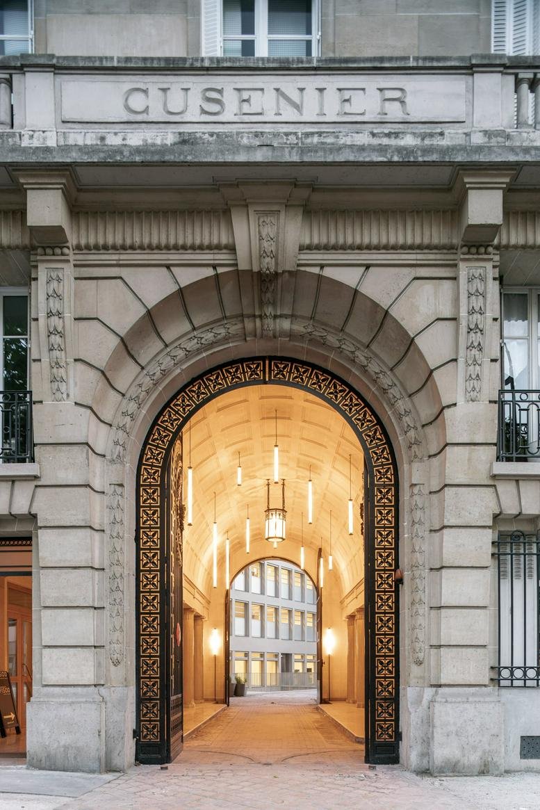 Entrance of the stone building at 226 Boulevard Voltaire, Paris with an illuminated archway.