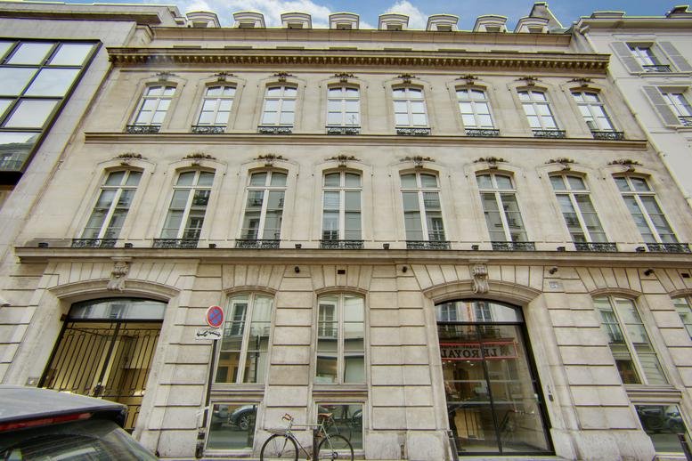 Classic stone facade of the 24 rue Cambaceres, Paris building with tall windows and arched entryways.