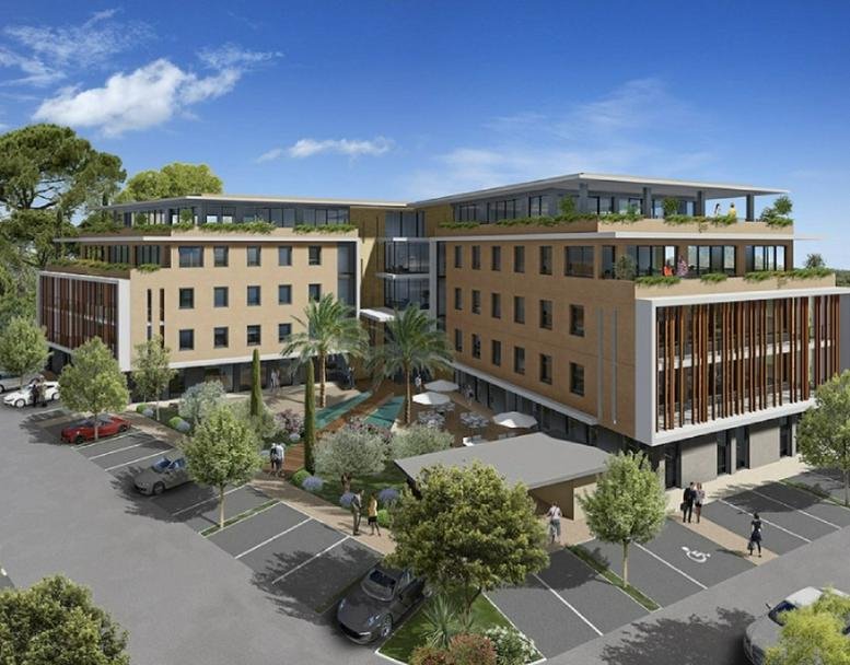 Exterior view of the modern Aix-TGV business center with landscaped courtyard and parking.