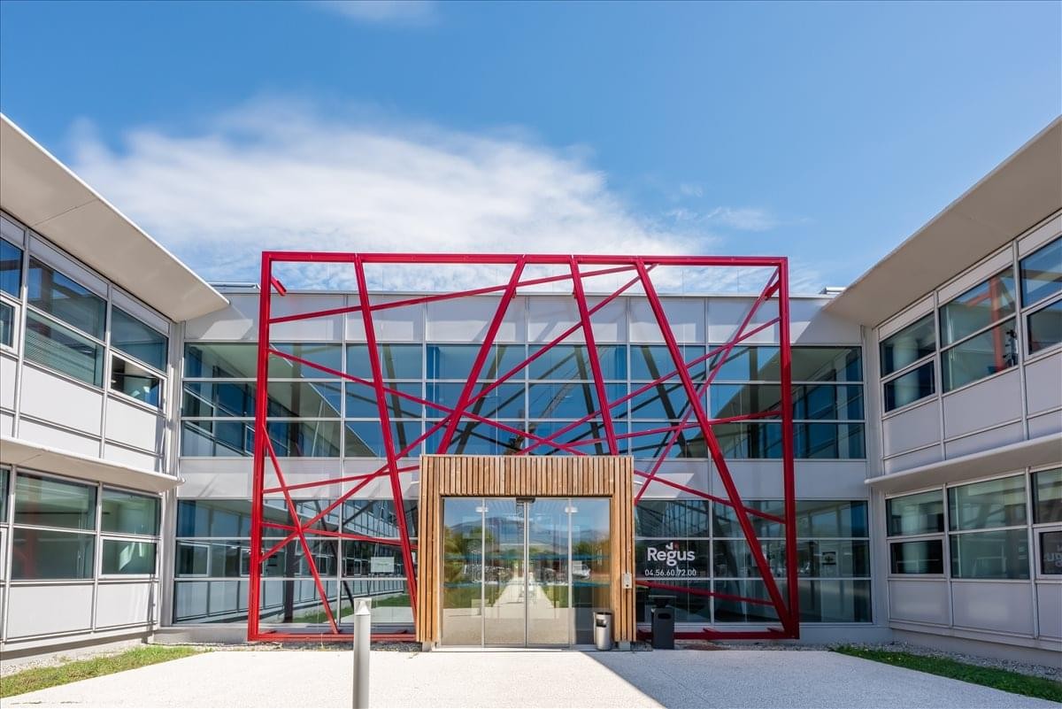 Exterior view of the modern office building at 26 Avenue Jean Kuntzmann with a striking red geometric facade.