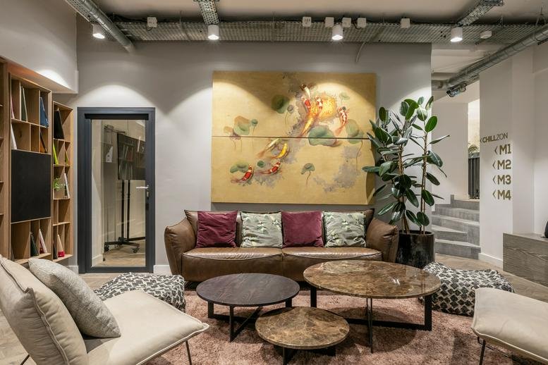 Spacious communal lounge at 27-29, Rue de Choiseul, Paris with a large mural and plush seating.