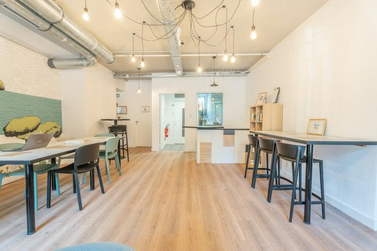 Spacious coworking lounge at 28, Boulevard de la Corderie, Marseille with wood floors and unique lighting.