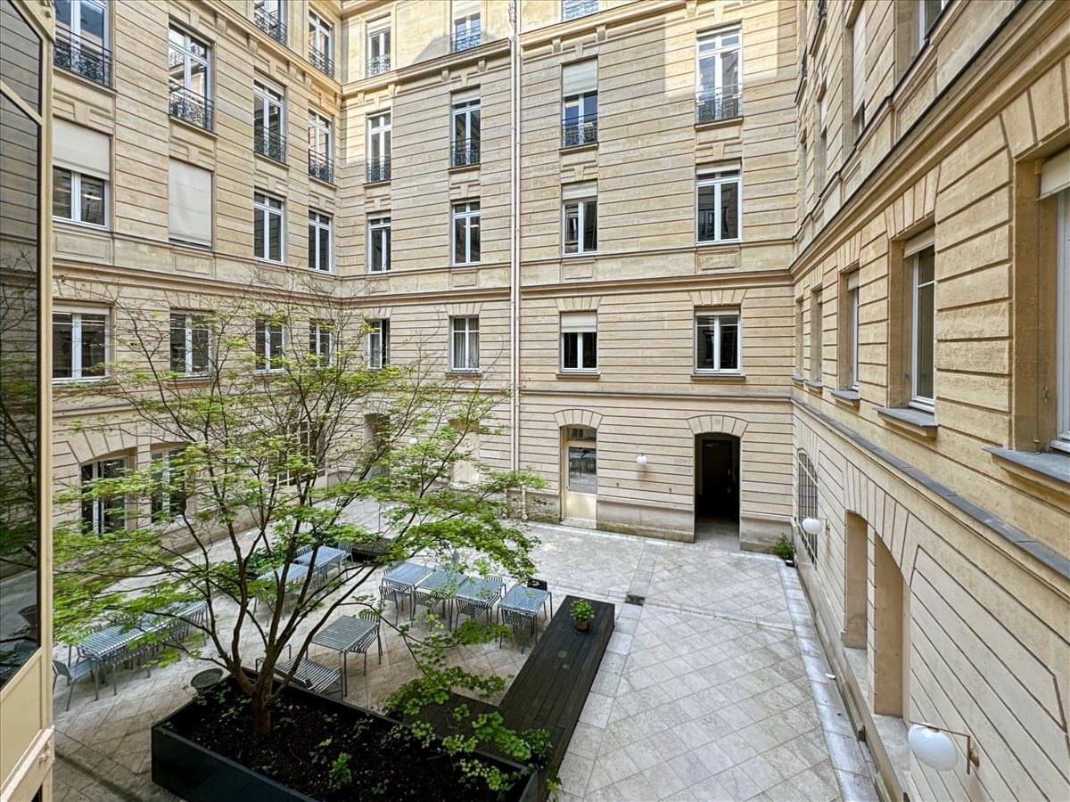 Inner courtyard view of the classic stone facade at 32-34 Avenue Kleber, Paris.