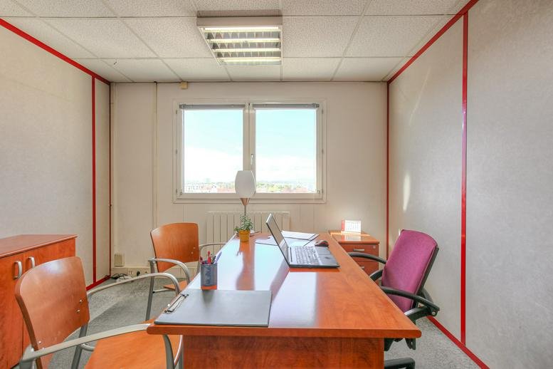 Office workspace at 320 Avenue Berthelot featuring a wooden desk and purple ergonomic chair.