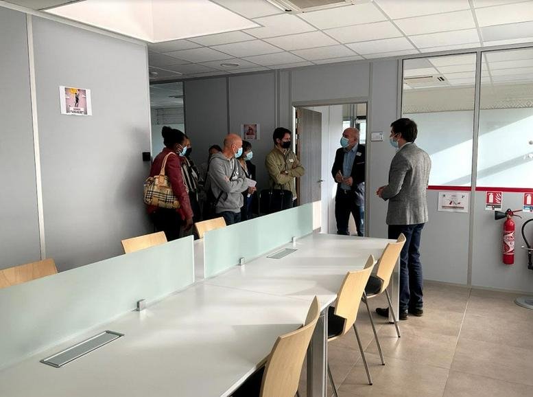 Bright shared workspace at 36 Rue Pascal with long white desks and wooden chairs.