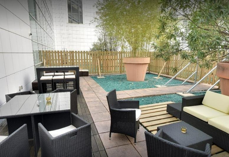 Rooftop terrace with modern outdoor furniture and potted bamboo plants at 39 rue du Château d’eau.