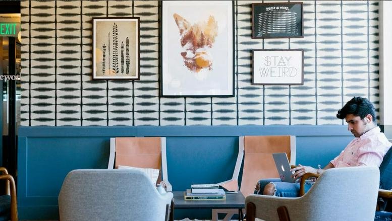 Lounge area with blue wood paneling, fox artwork, and patterned wallpaper at 4 Rue Jules Lefebvre.