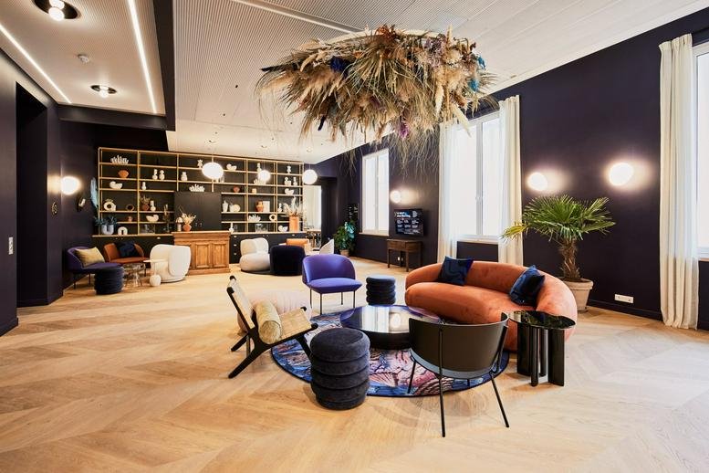 Spacious communal lounge at 4, Rue Royale, Paris featuring a large botanical ceiling installation and velvet seating.