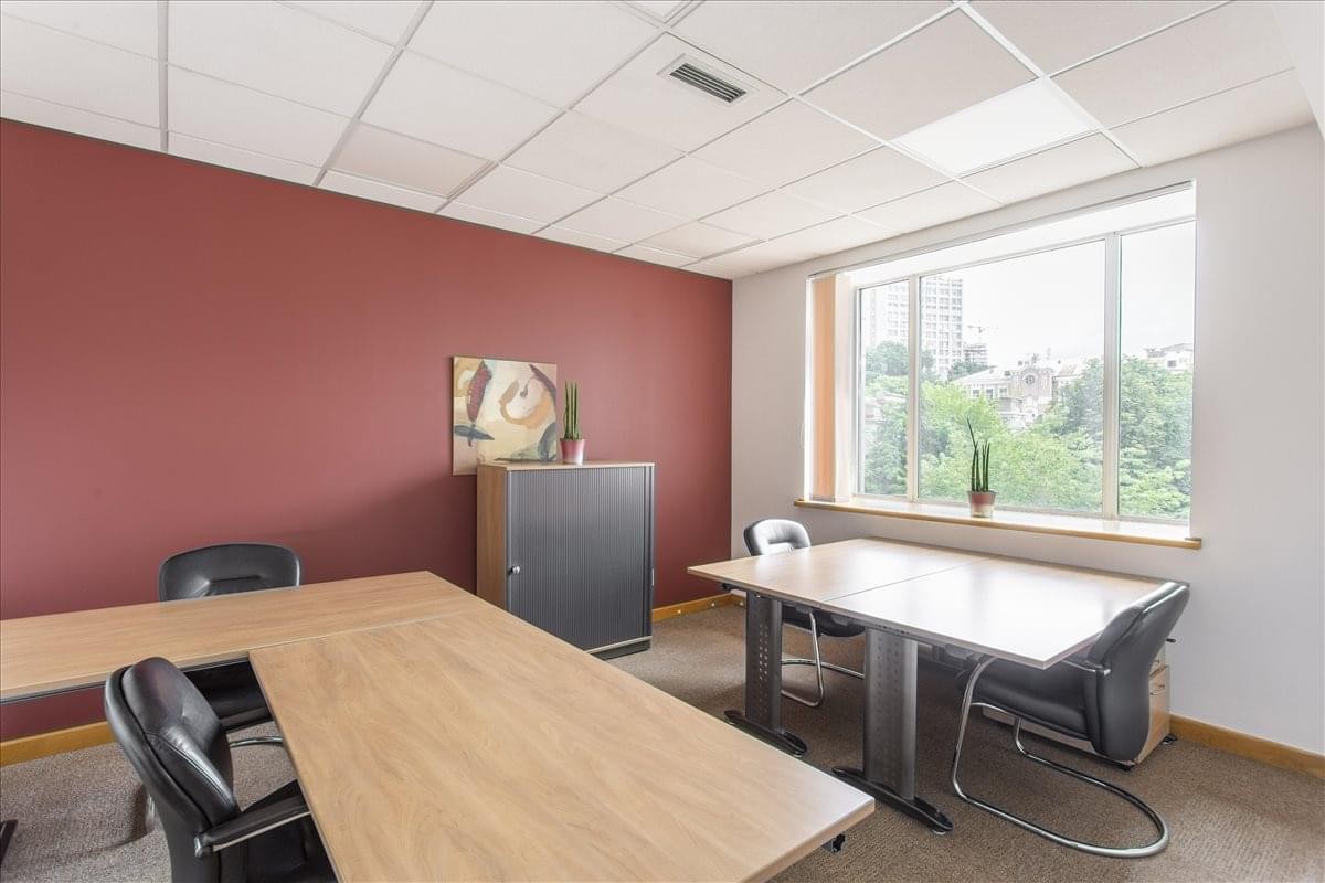 Private office with a red feature wall and large window at 42-44 Shovkovychna str, Kiev.