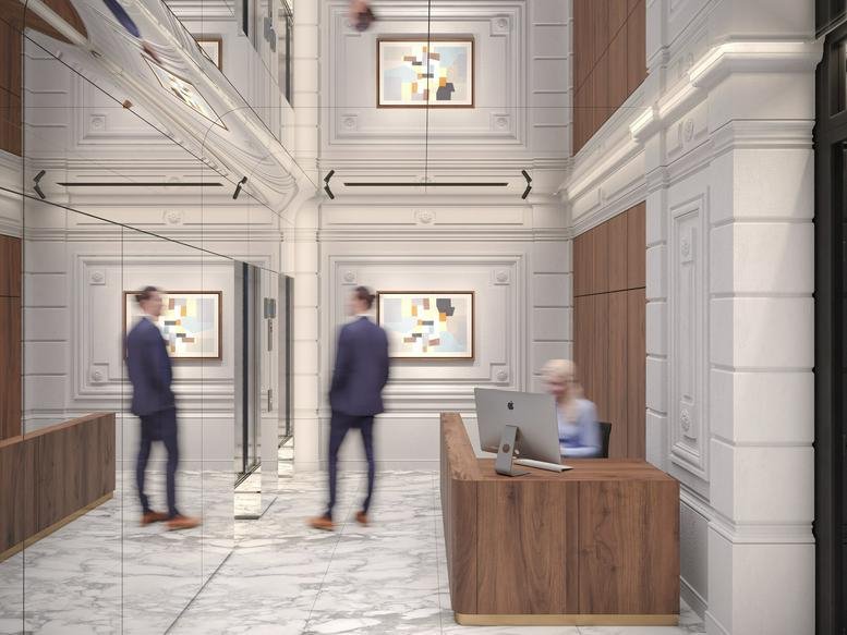 Elegant reception area at 43 Avenue de l’Opéra featuring a wood desk and ornate wall moldings.