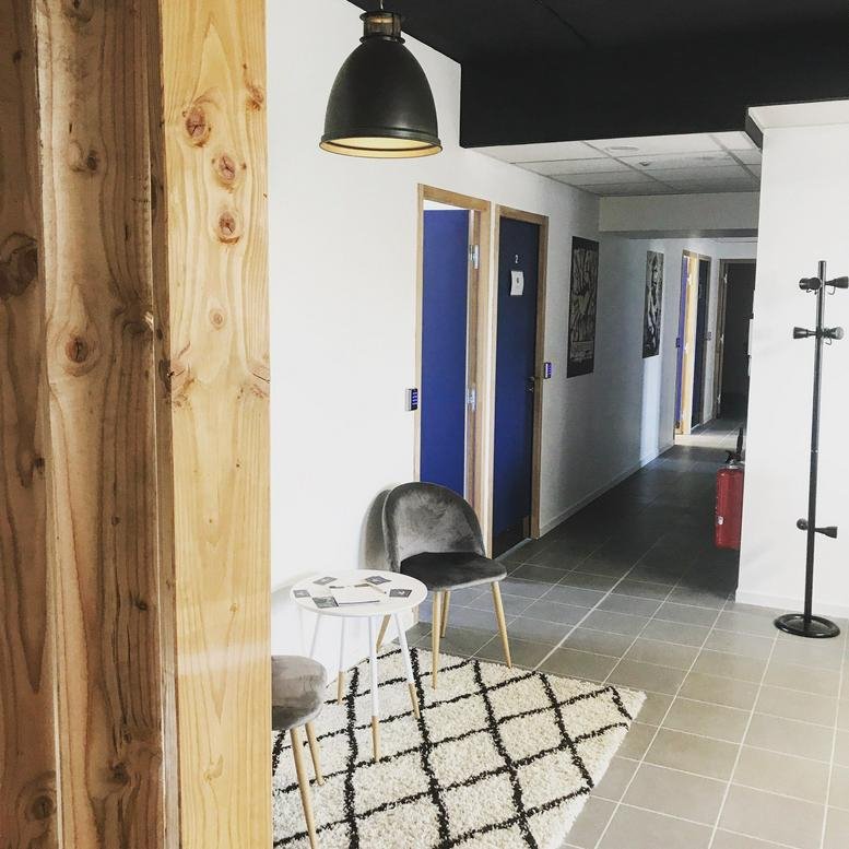 Reception area at 45 Avenue De Coriandre with a modern chair, patterned rug, and bright hallway.