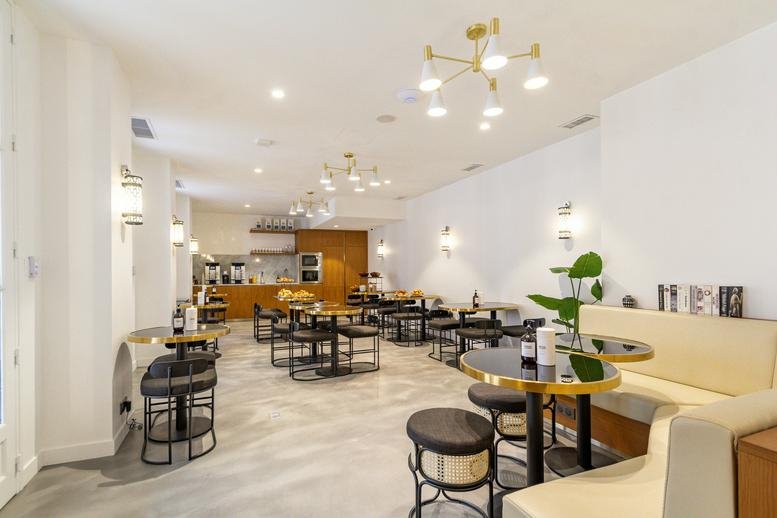 Spacious communal lounge at 48-50 Rue de Taitbout with modern light fixtures and varied seating.