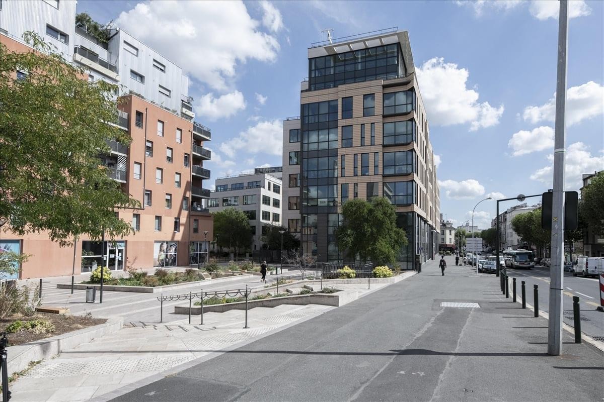 Exterior view of the modern 5 Rue Charles de Gaulle building under a bright blue sky.