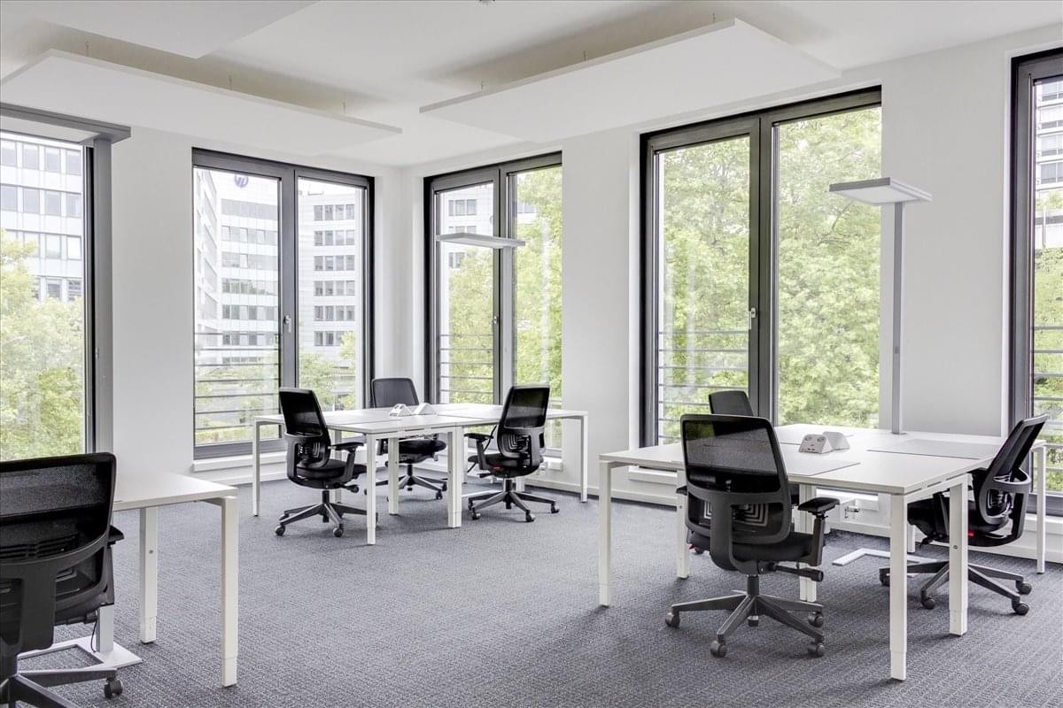 Spacious open-plan workspace at 52 Avenue Aristide Briand with several white desks and large windows.