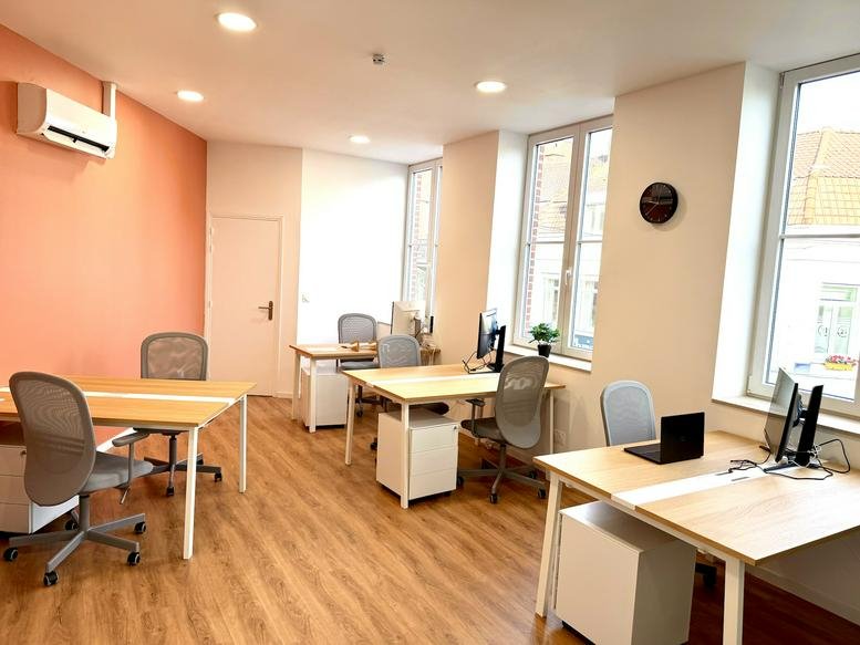 Spacious open-plan workspace at 53, Rue Nationale, Tourcoing, Hauts-de-France with wooden floors and coral accent wall.