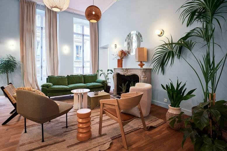 Spacious communal lounge at 69-71 rue de Miromesnil, Paris with velvet sofas, plants, and high ceilings.