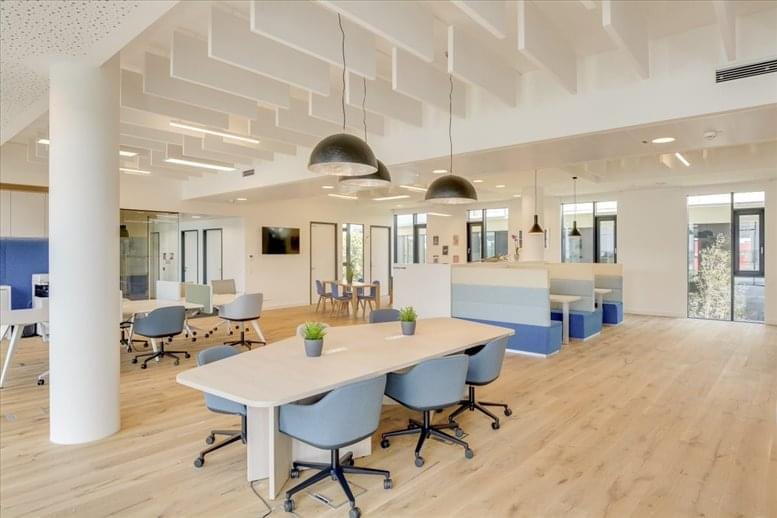 Spacious coworking area at 7-9 Boulevard Thomas Gobert, Palaiseau with modern pendant lights and blue seating.