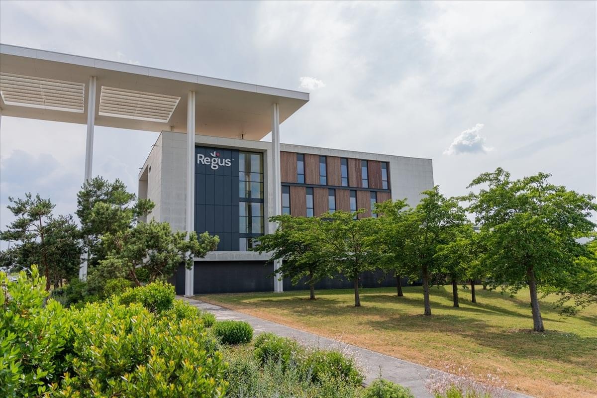 Exterior view of the modern 8 Avenue de Shenzhen building with green space and a covered entrance.