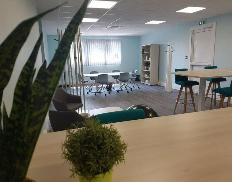 Meeting room at 8 Bis rue Gabriel Voisin, Pôle Technologique FARMAN, featuring modern chairs and a green plant.