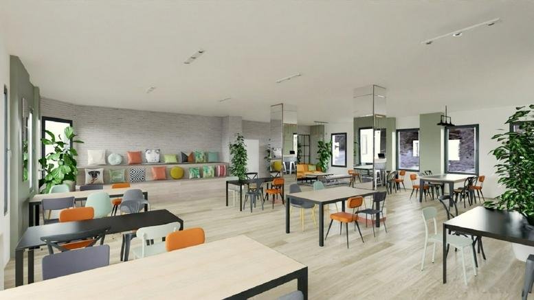 Spacious communal coworking area at Maison Mozart, 4th Floor, 8 Rue du Sentier, Paris with colorful chairs and plants.