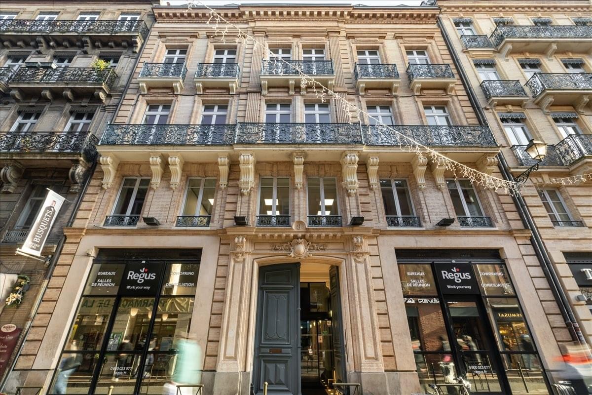 Grand stone facade of the historic building at 8 Rue Rémusat in Toulouse.