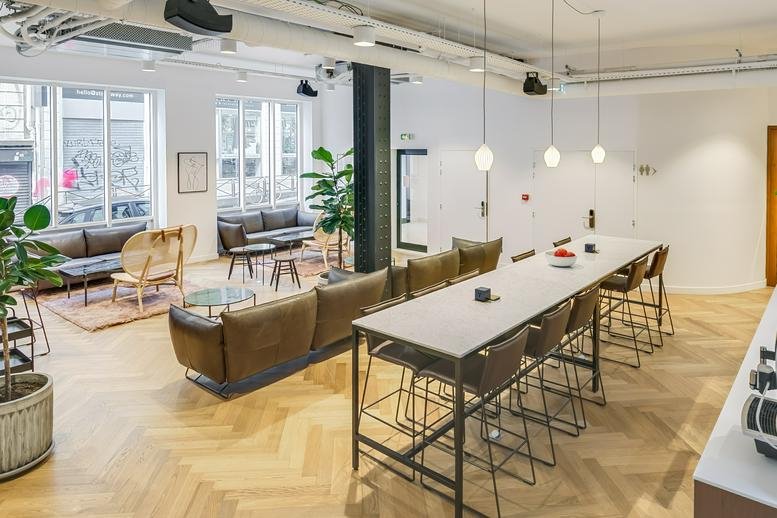 Spacious communal lounge at 86-90 rue Notre Dame de Nazareth 3e, Paris with herringbone floors and mid-century furniture.
