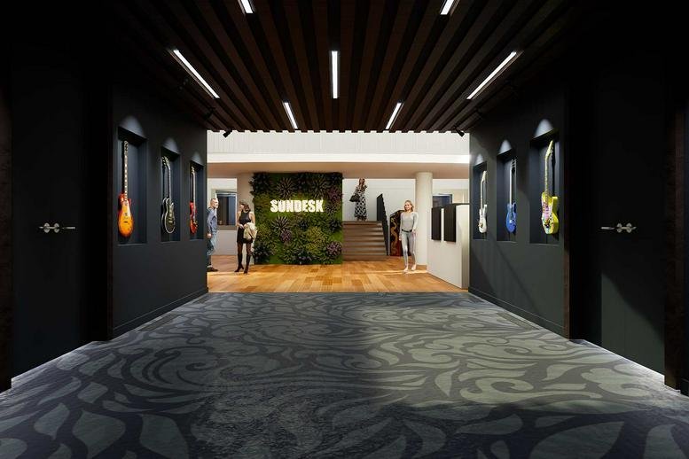 Spacious reception lobby at 930 route des Dolines with a green plant wall and guitar display.