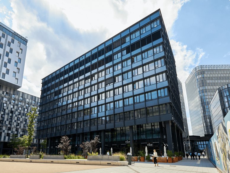 Exterior view of the modern glass-facade building at Am Belvedere 8 und 10.