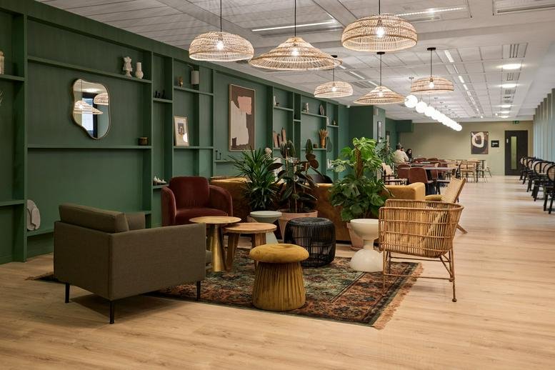 Spacious communal lounge at Auber, 6 Rue Auber, Paris featuring green wood-paneled walls and wicker pendant lights.