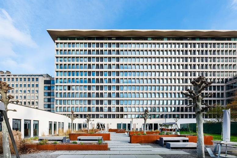Exterior view of the modernist building at Avenue Louise 231, Brussels with a tiered white facade.