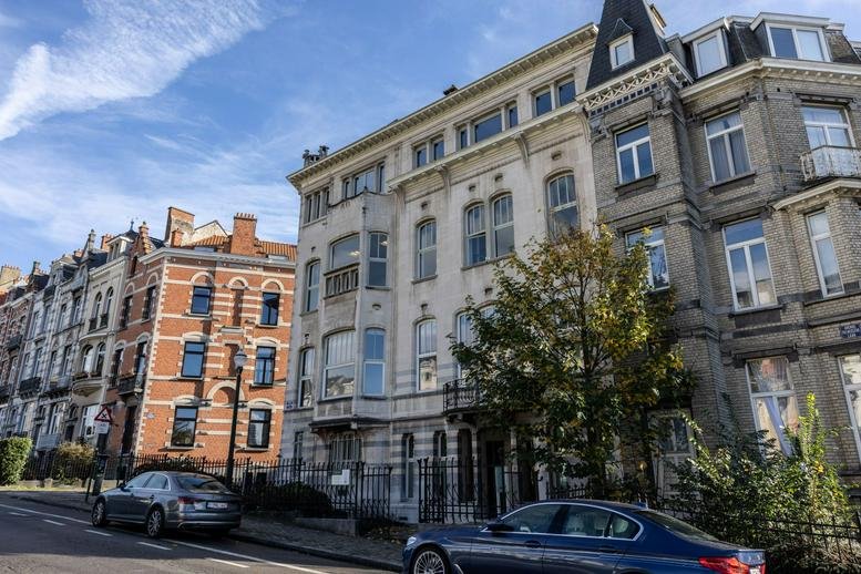 Exterior view of the historic stone and brick facade at Avenue Palmerston 3, Victor Horta, Brussels.