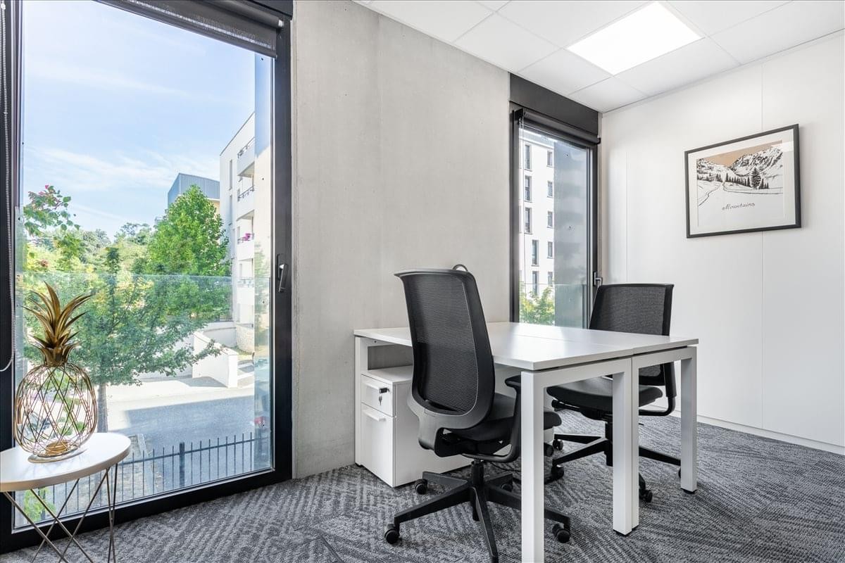 Avenue Pierre-George Latecoère office with large windows overlooking trees and a white desk.
