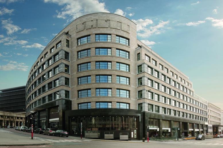 Exterior view of the curved stone facade at Cantersteen 39-55, Brussels.