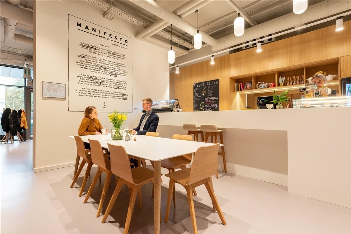 Spacious communal cafe area at Capital Towers, 22 Korolenkivska Street featuring a large wooden dining table.