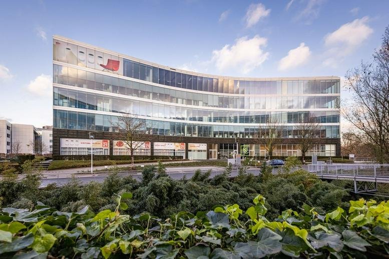 Exterior view of the curved glass facade at Da Vincilaan 2, Brussels Airport, Zaventem.