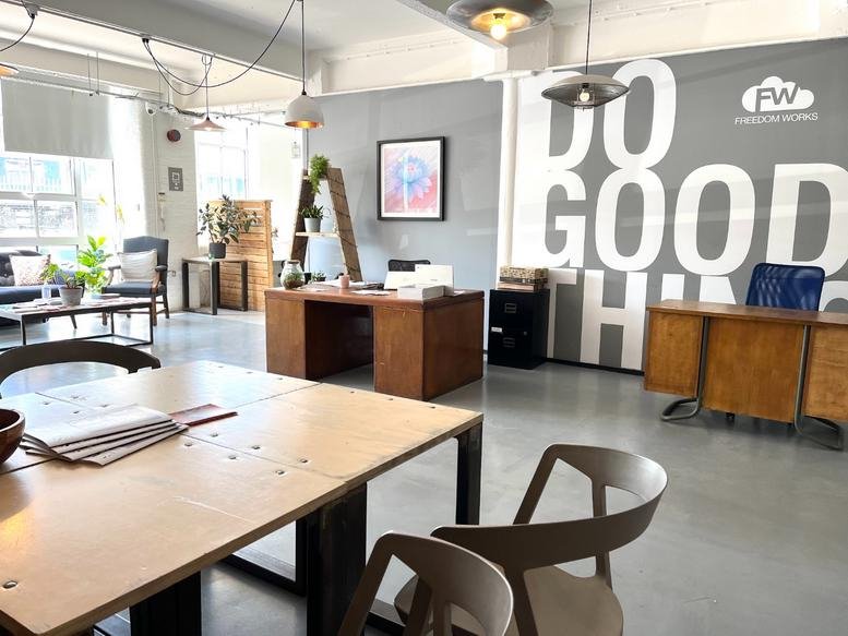 Spacious interior of Freedom Works Creative Hub, Unit 7 Hove Business Centre, Fonthill Road with wooden desks.