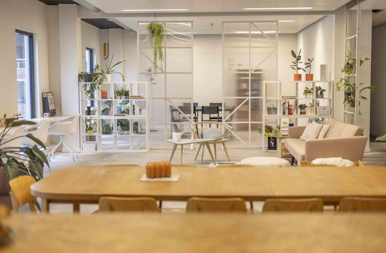 Spacious communal lounge at Hendrik Consciencestraat 5, Bus 0301, Mechelen with warm wooden tables and many indoor plants.