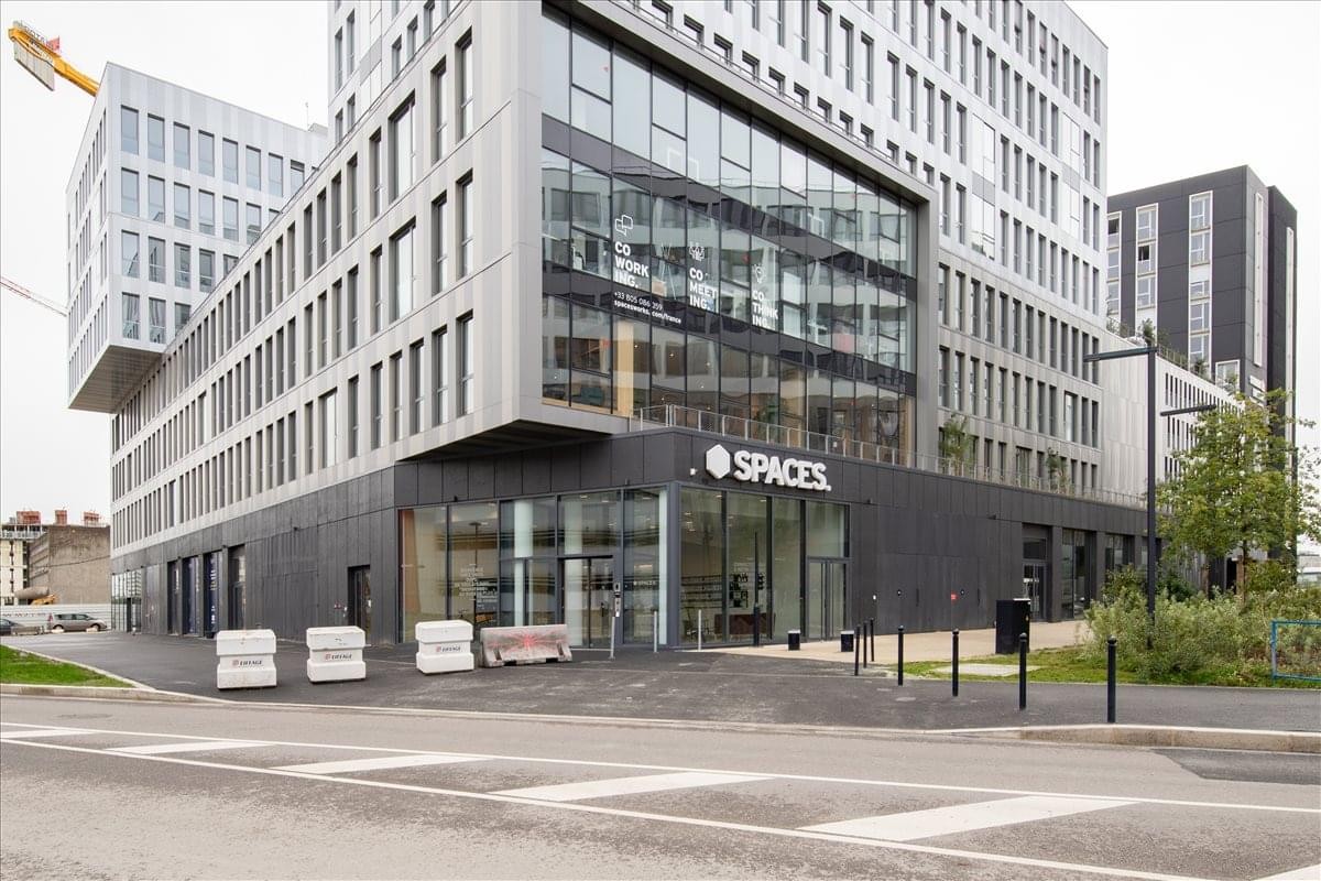 Modern exterior of Ilot Quai 8. 2, Bâtiment E1 with large glass windows and the Spaces logo.