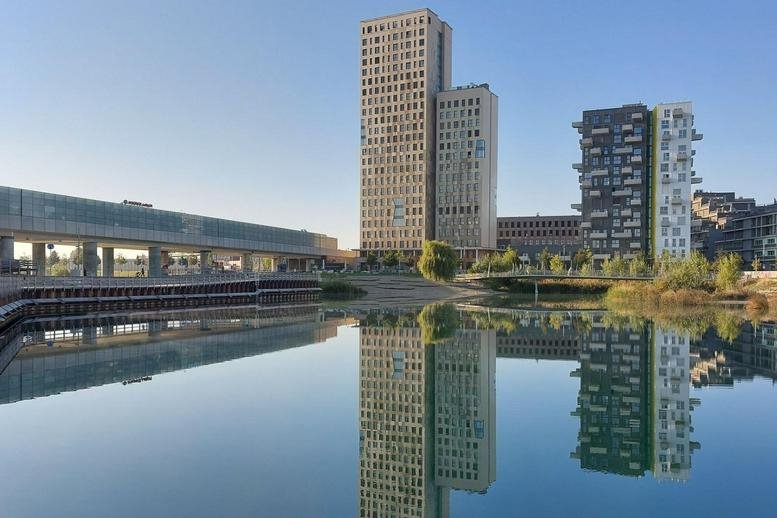 City skyline view featuring the main building reflected in a calm waterfront.